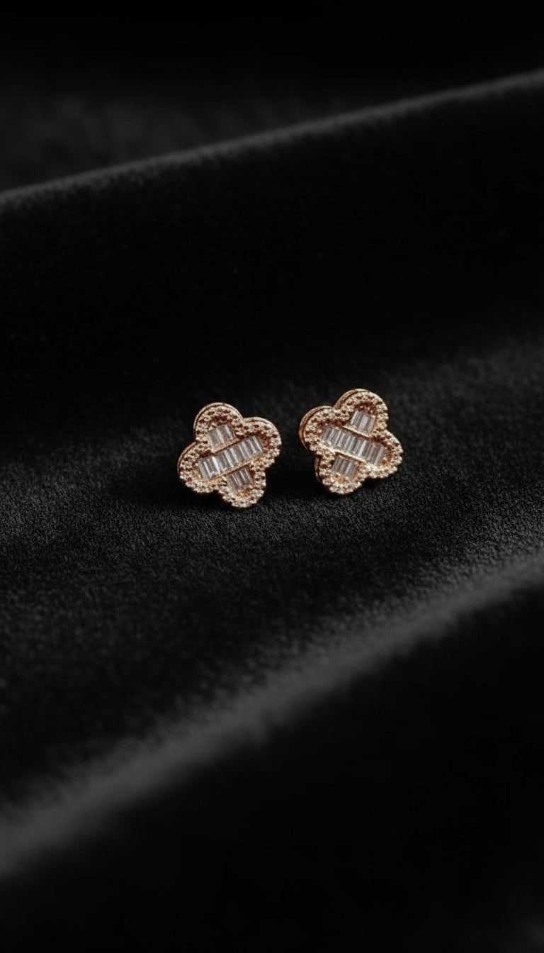 Rose gold earrings with diamond accents on a black velvet background