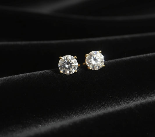 Diamond stud earrings on a black velvet surface
