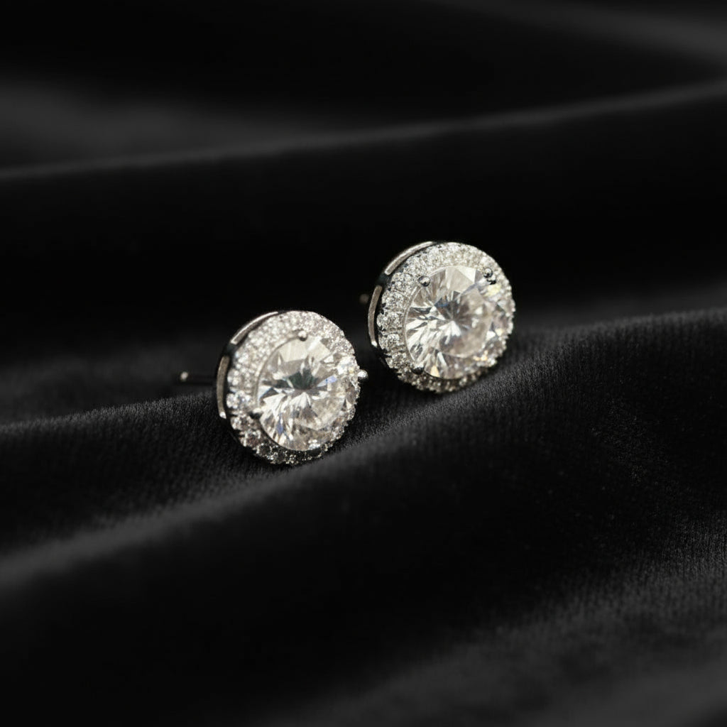 Pair of diamond stud earrings on a black velvet background