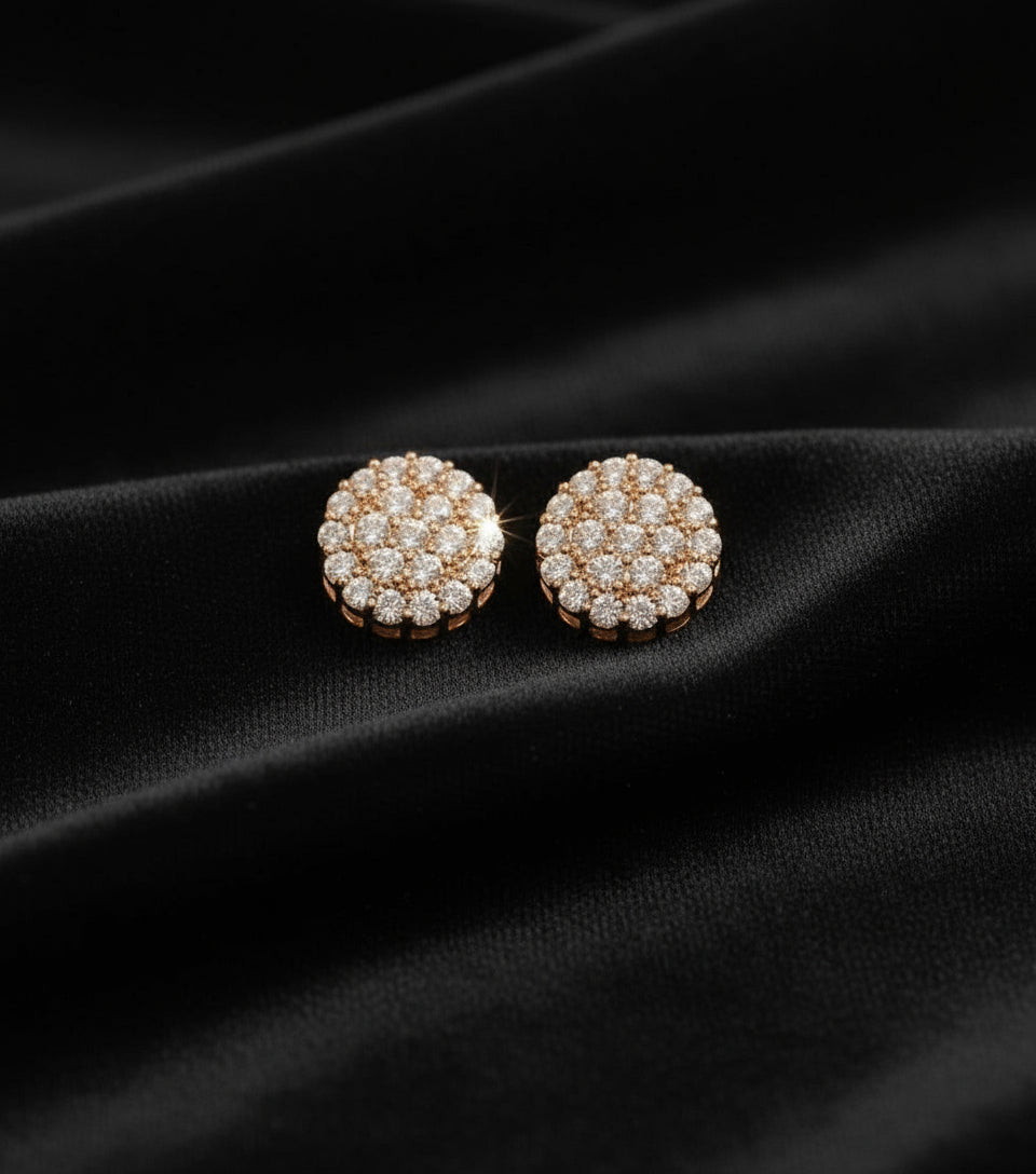 Pair of round earrings with diamond-like stones on a black fabric background
